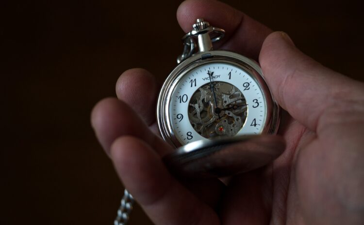 A photo of a hand-held clock showing the time