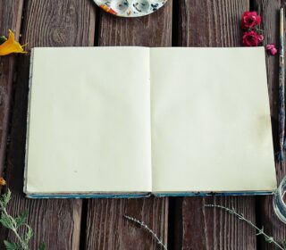 A photo showing a blank sketchbook and a background of flowers