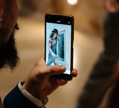 A photo showing a bearded man taking a photo of a model on a catwalk