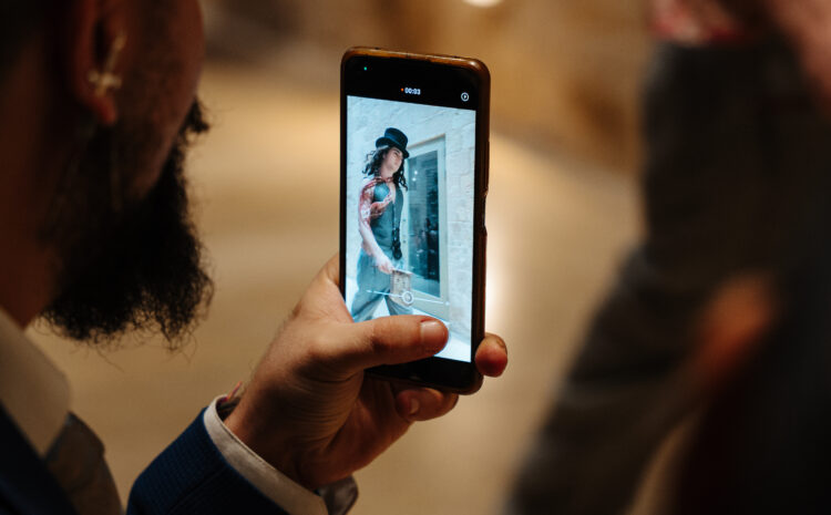 A photo showing a bearded man taking a photo  of a model on a catwalk