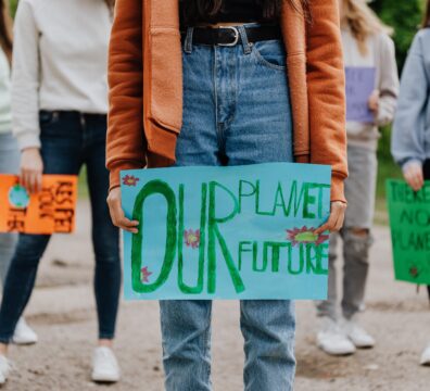 A photo showing a group of people holding plackards with messages about the planet