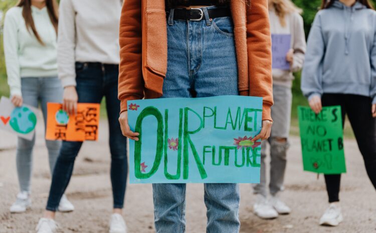 A photo showing a group of people holding plackards with messages about the planet