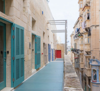 A photo showing teal doors at the Valletta Design Cluster set against the Valletta urban backdrop