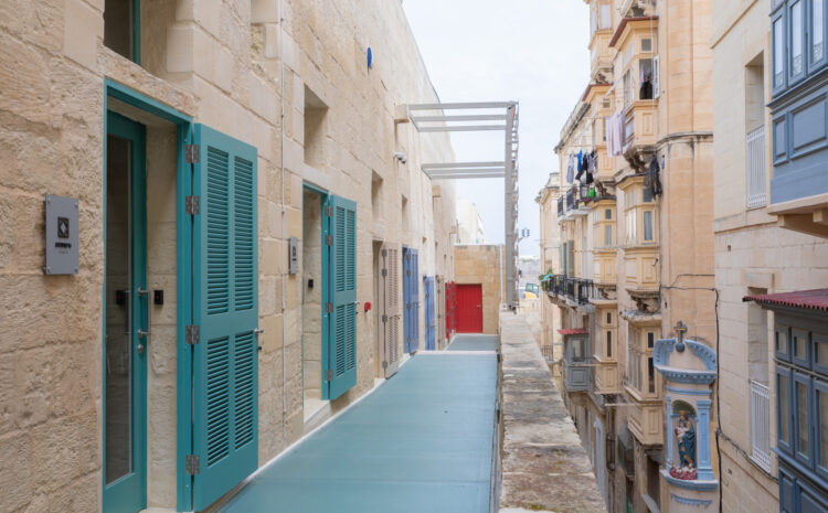 A photo showing teal doors at the Valletta Design Cluster set against the Valletta urban backdrop