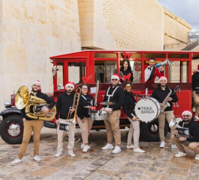 A photo of Tikka Banda with a red Karwija bus in Valletta