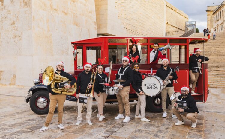 A photo of Tikka Banda with a red Karwija bus in Valletta