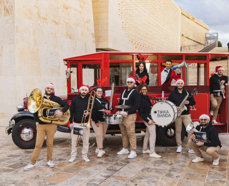 A photo of Tikka Banda with a red Karwija bus in Valletta