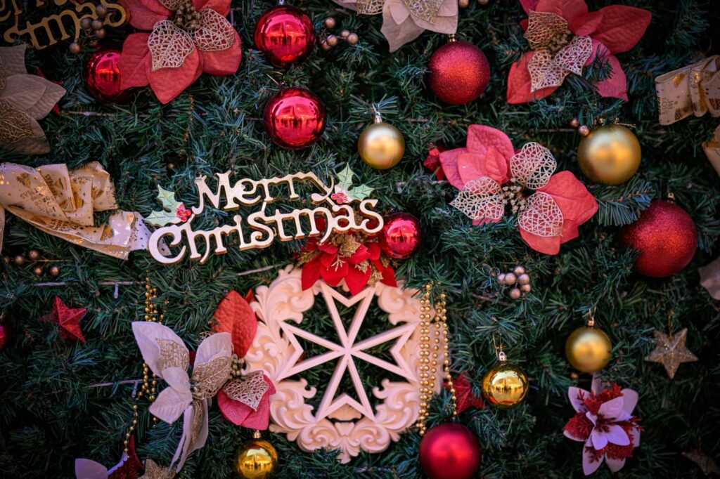 A photo showing a detail of the Valletta national Christmas Tree with a Maltese Cross ornament with the text Merry Christmas