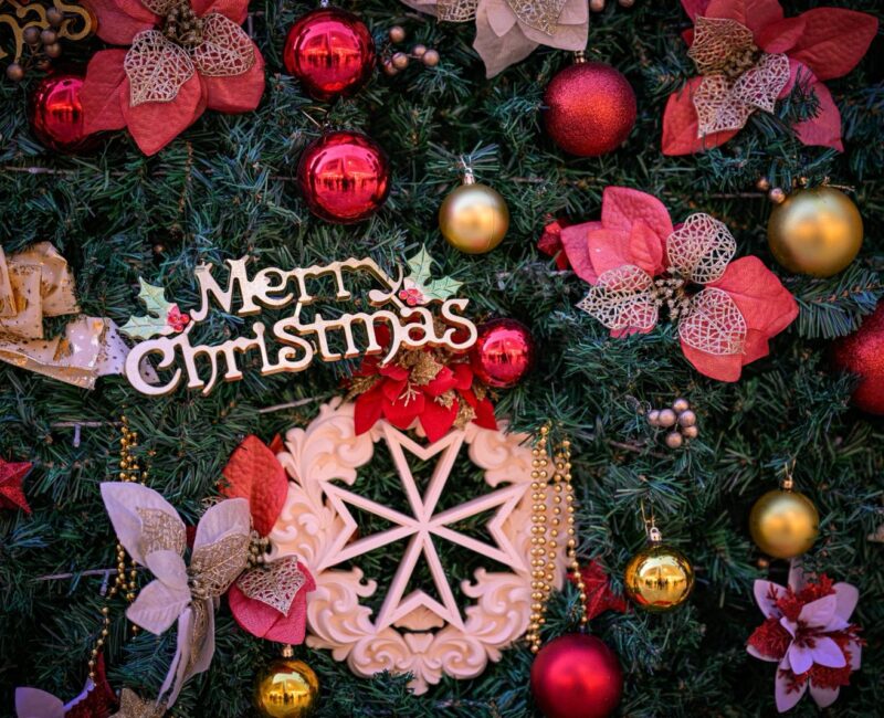 A photo showing a detail of the Valletta national Christmas Tree with a Maltese Cross ornament with the text Merry Christmas
